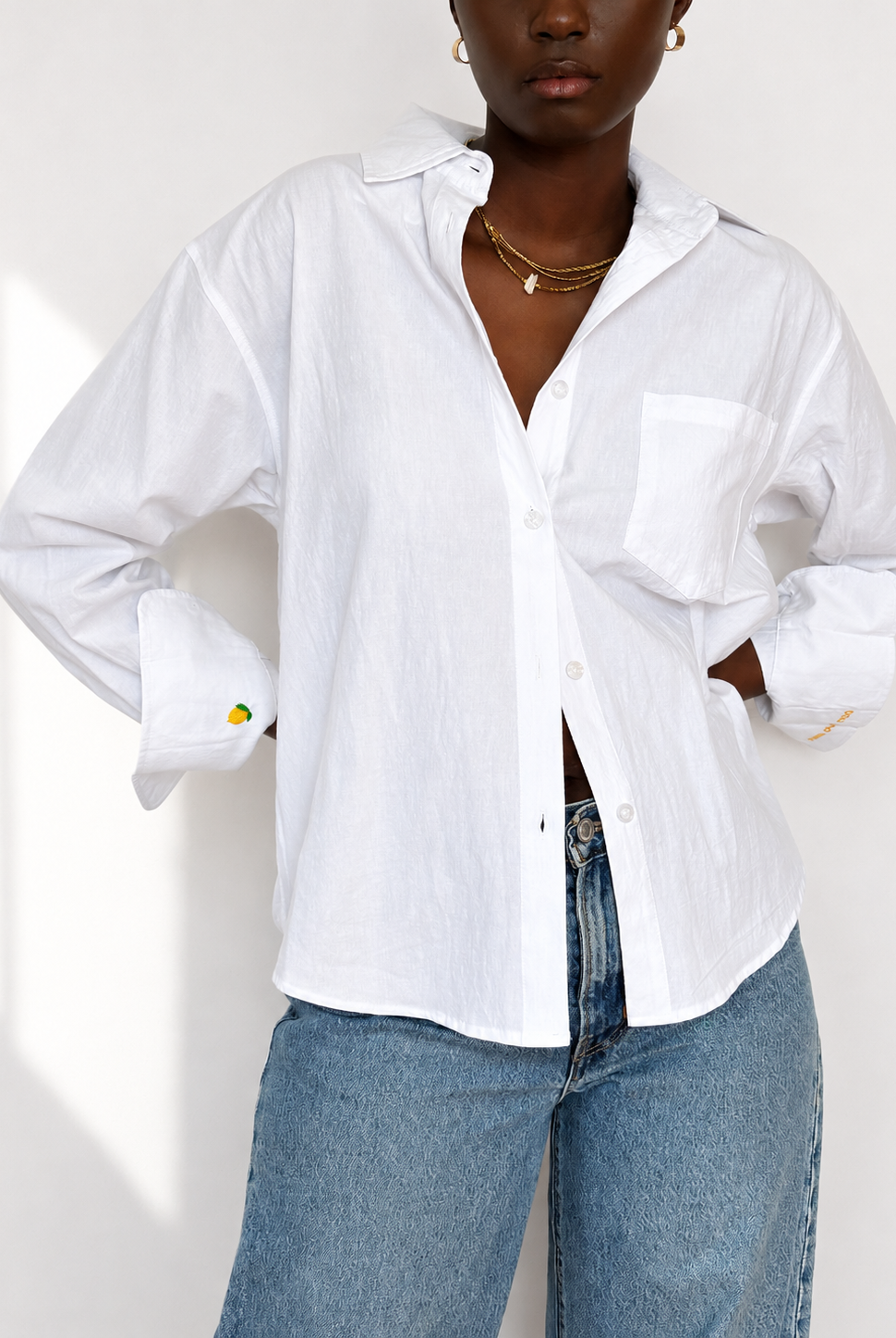 White embroidered cotton Everyday Boyfriend Shirt with lemon cuff detail, styled with jeans.
