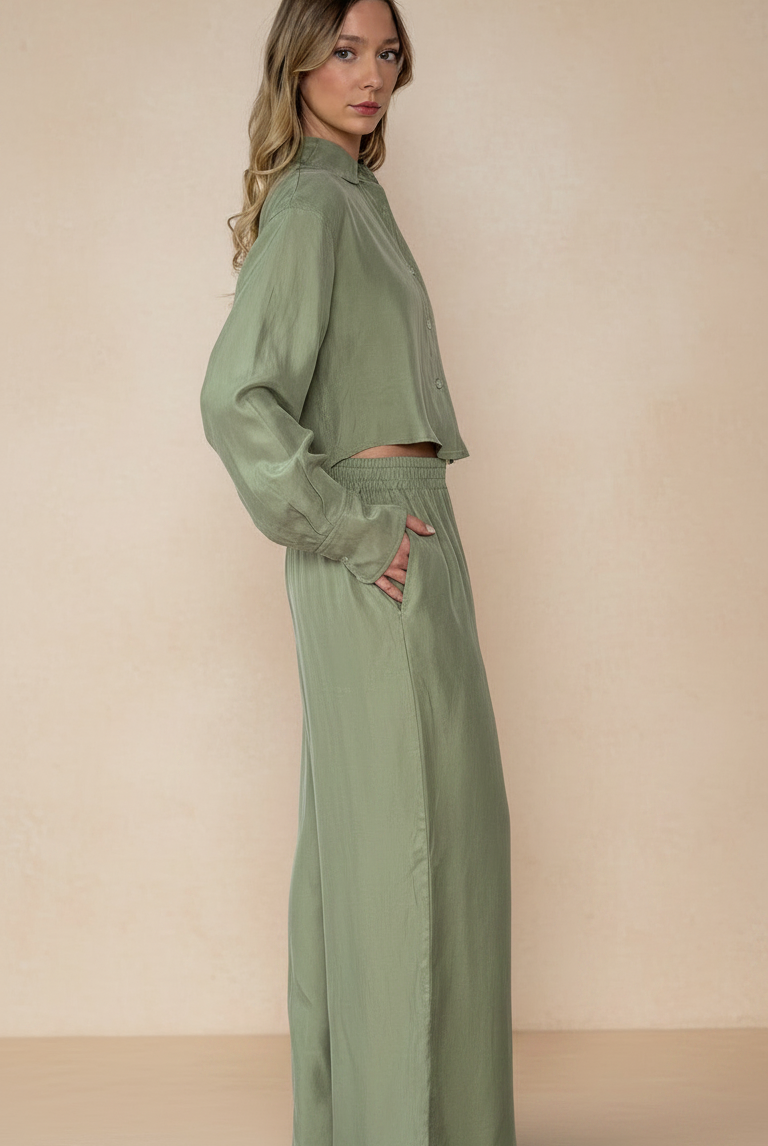 Woman wearing a matching green outfit against a beige background