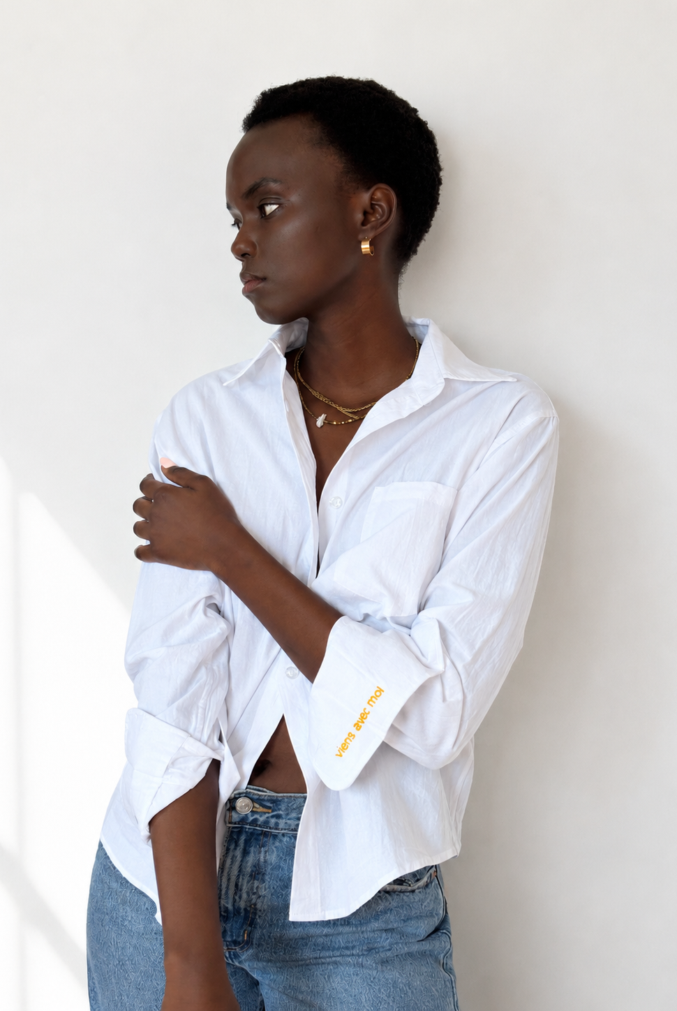 White embroidered cotton Everyday Boyfriend Shirt with "viens avec moi" cuff detail, worn by a model.