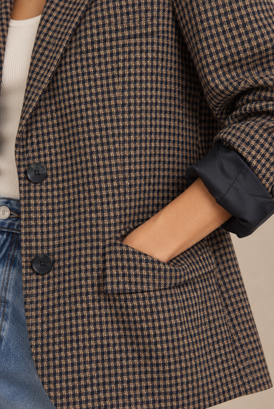 Close-up of navy and camel check blazer with flap pocket, buttons and rolled navy-lined cuff