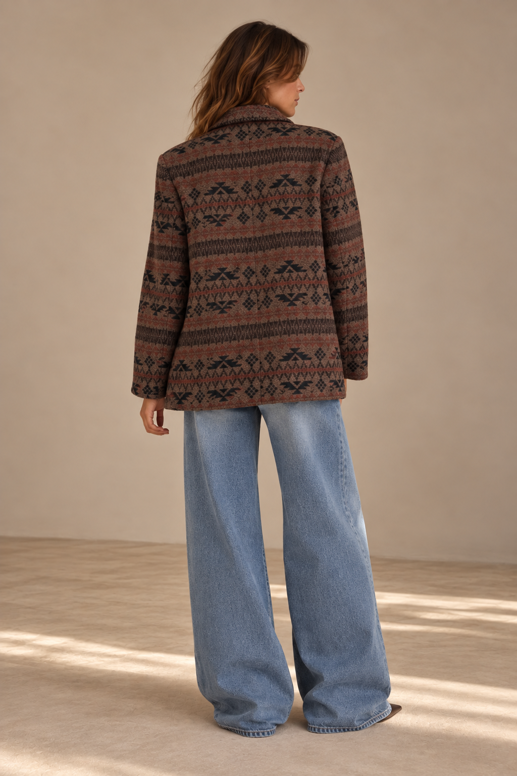 Woman wearing vintage brown and rust geometric jacquard coat with wide-leg jeans, back view