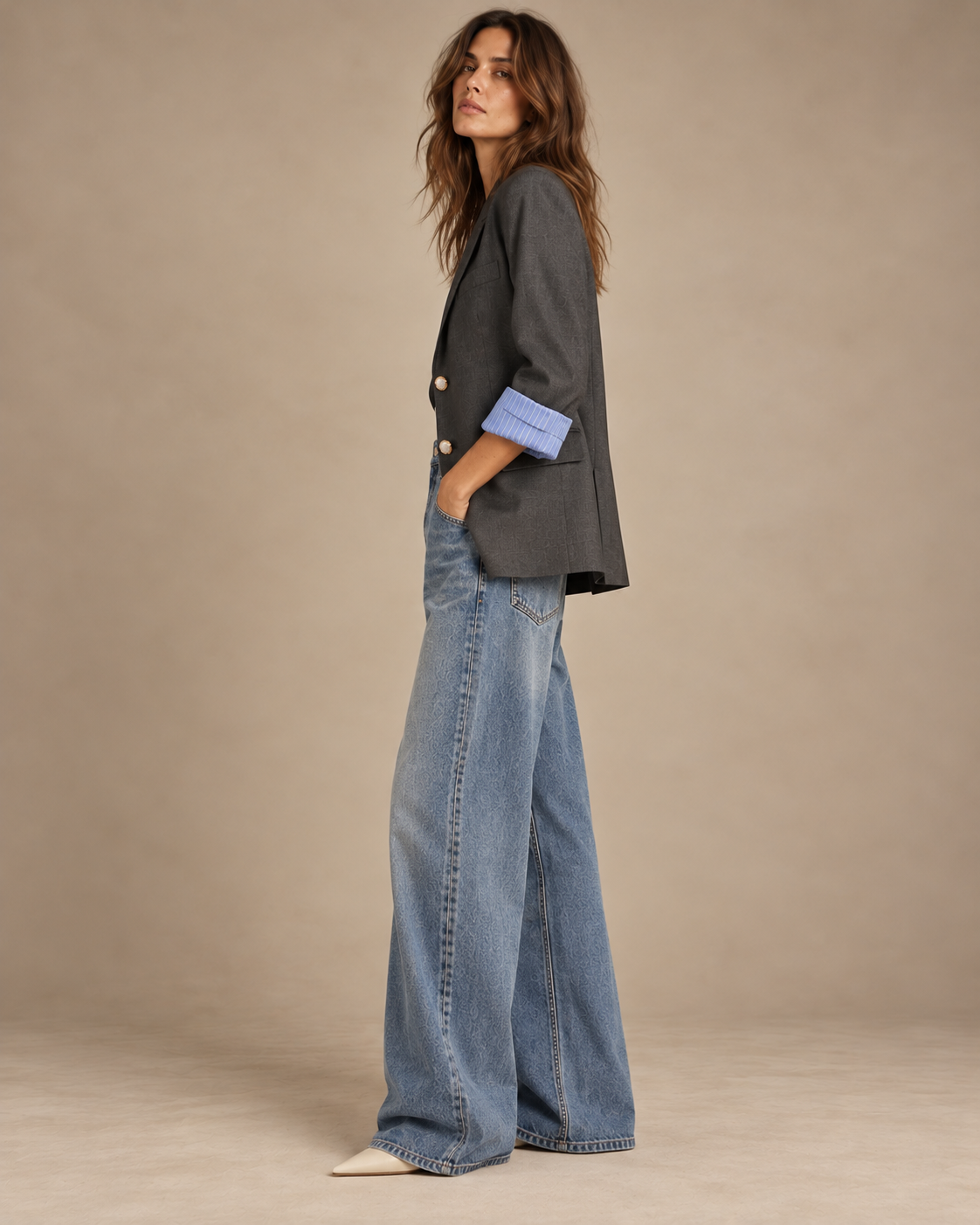 Side view of charcoal vintage blazer with striped cuff and wide-leg jeans