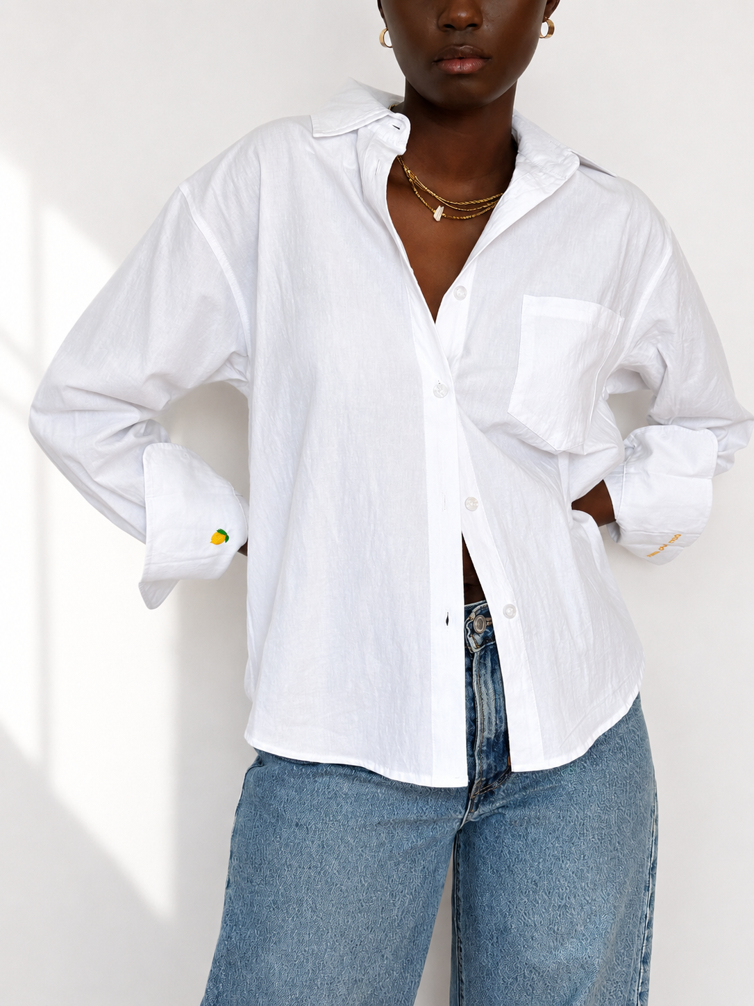 White embroidered cotton Everyday Boyfriend Shirt with lemon cuff detail, styled with jeans.