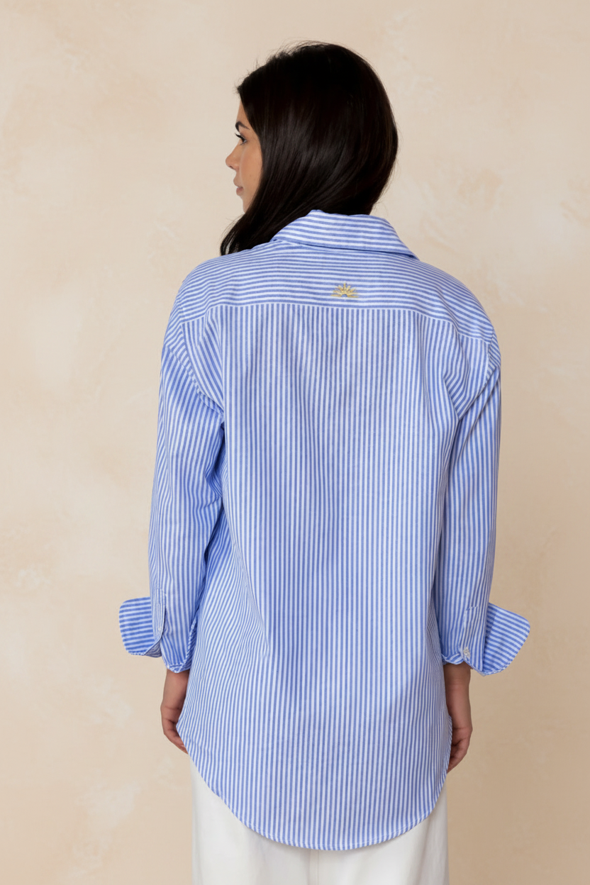 Woman wearing a blue and white striped shirt against a beige background