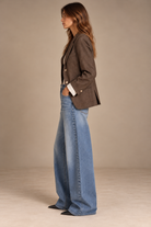 Vintage brown blazer, side view, with sleeves turned up over striped shirt