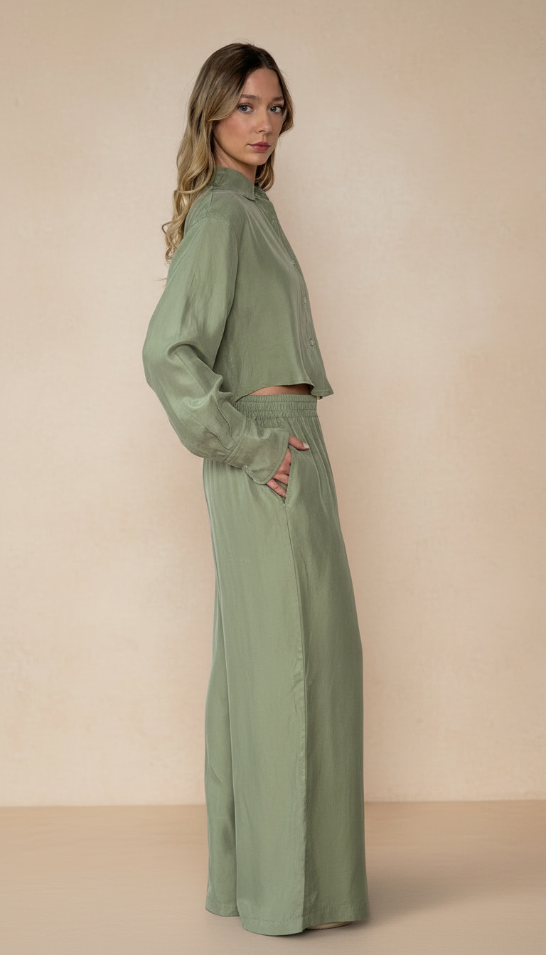 Woman wearing a matching green outfit against a beige background