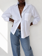 White embroidered cotton Everyday Boyfriend Shirt, relaxed fit, styled with jeans.