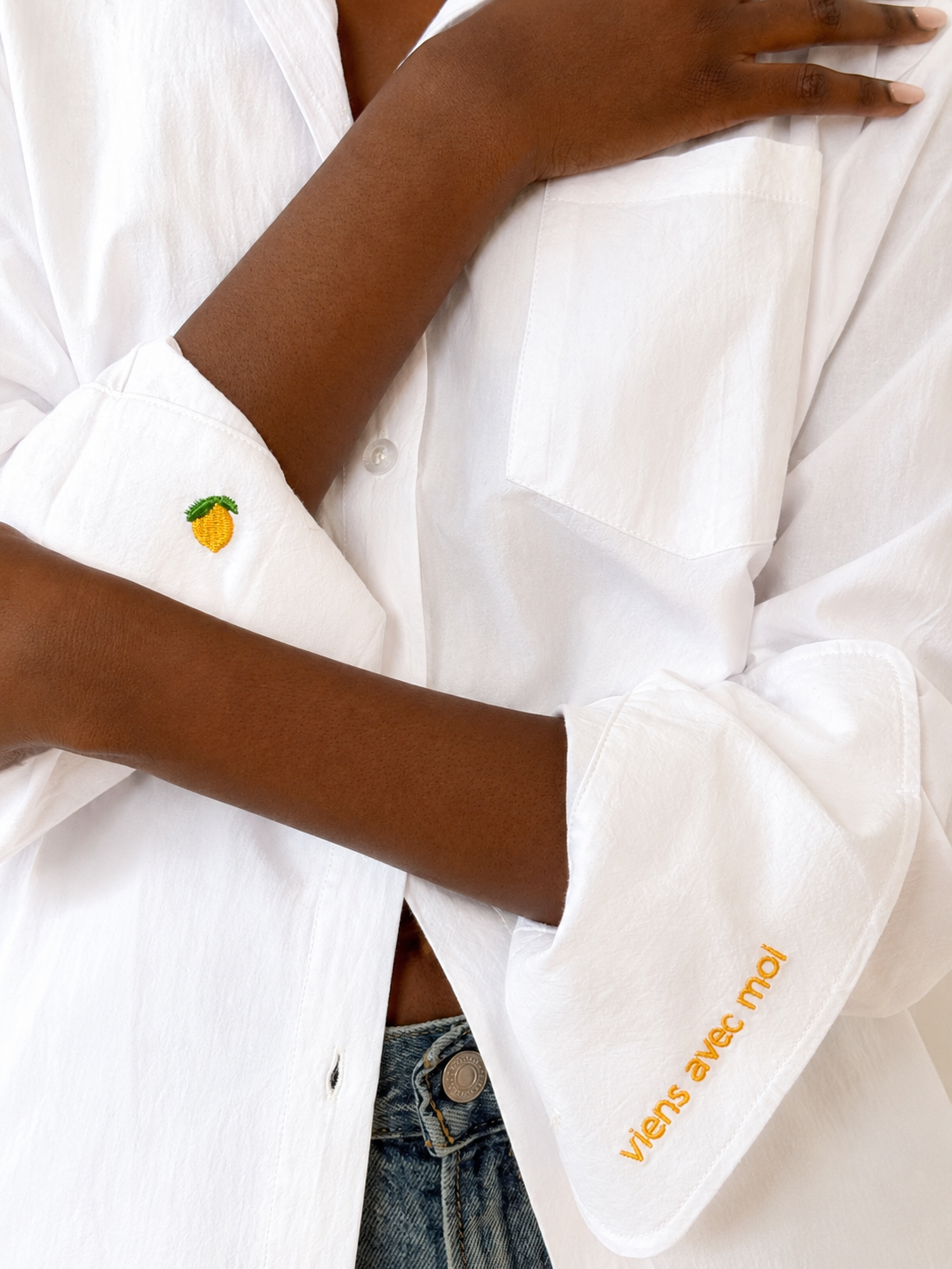 White embroidered cotton button-down shirt with "viens avec moi" cuff and lemon detail.