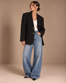Vintage oversized black pinstripe blazer with gold buttons worn with white tank and wide-leg jeans