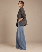 Side view of vintage check blazer with hand in pocket and wide-leg jeans