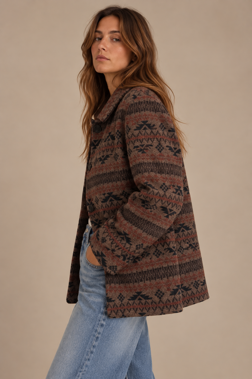 Woman wearing vintage brown and rust geometric jacquard coat with wide-leg jeans, side view